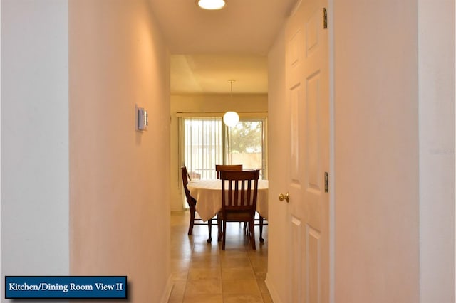 corridor featuring light tile patterned floors and baseboards