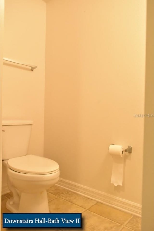 bathroom with tile patterned floors, toilet, and baseboards