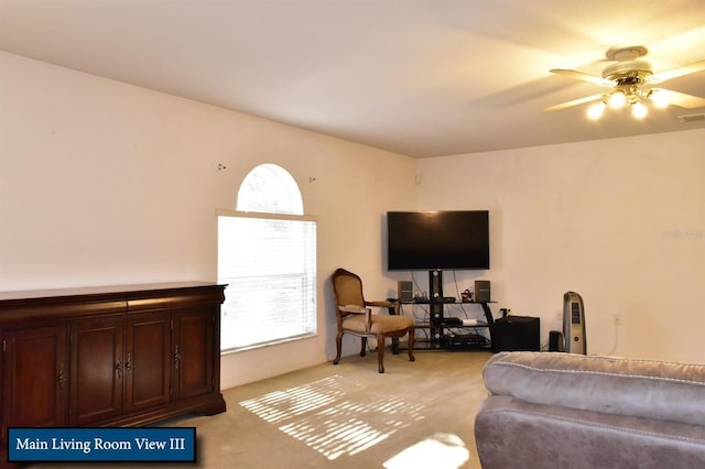 living room with ceiling fan, visible vents, and light colored carpet