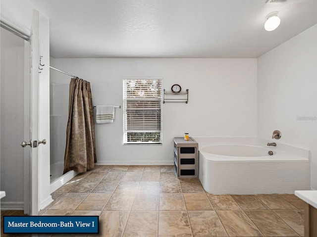 full bath featuring baseboards, a garden tub, and a shower stall