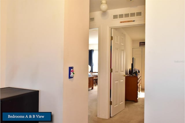hallway with light carpet and visible vents