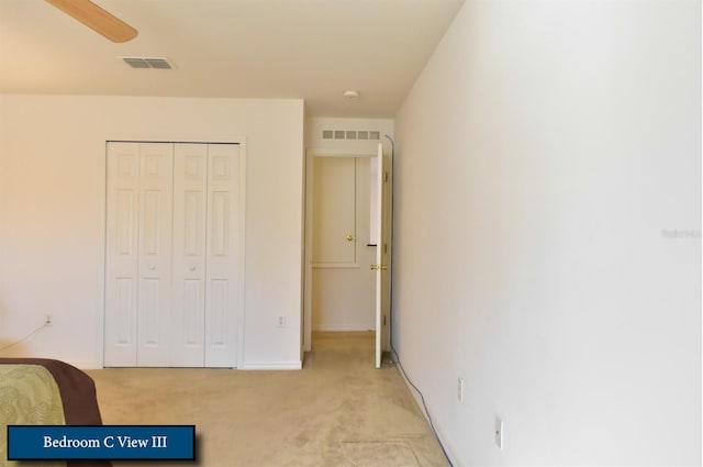 bedroom with a closet, baseboards, visible vents, and light colored carpet