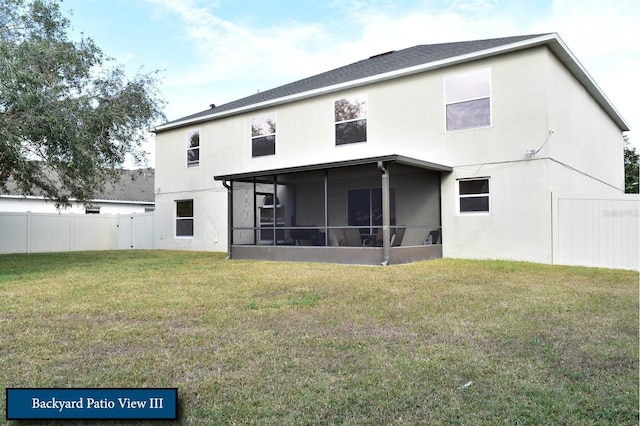 rear view of property featuring stucco siding, a sunroom, fence, and a yard