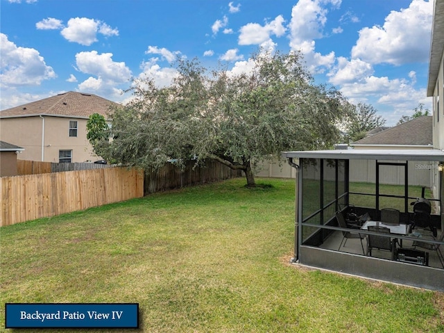 view of yard with a sunroom and a fenced backyard