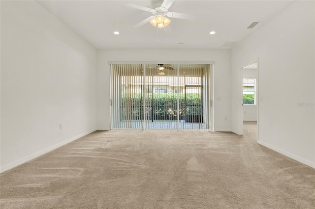 spare room featuring light colored carpet and ceiling fan