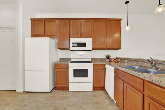 kitchen with light tile patterned floors, white appliances, sink, and decorative light fixtures