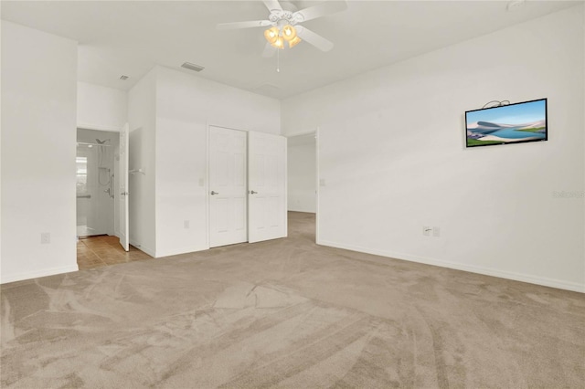 unfurnished bedroom with light carpet, ceiling fan, and ensuite bath