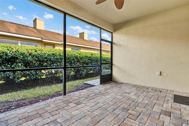 unfurnished sunroom with ceiling fan