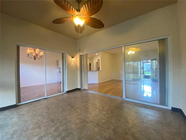 unfurnished bedroom featuring ceiling fan with notable chandelier and hardwood / wood-style flooring