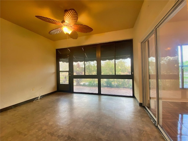 unfurnished sunroom with ceiling fan