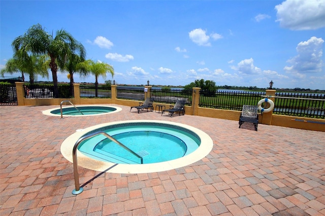 view of swimming pool featuring a patio and a hot tub