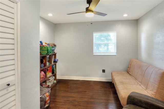 living area with ceiling fan and dark hardwood / wood-style flooring