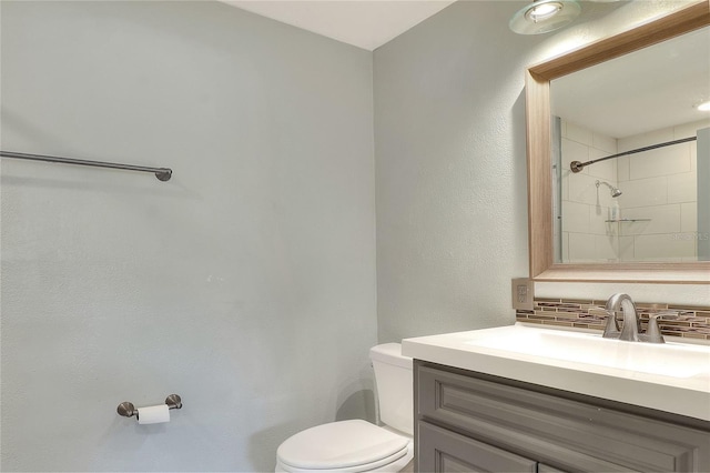 bathroom featuring decorative backsplash, vanity, and toilet