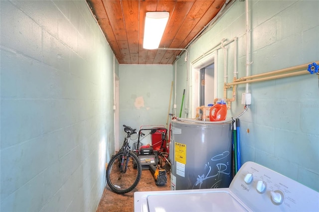 laundry room featuring washer / clothes dryer, water heater, concrete block wall, and wood ceiling