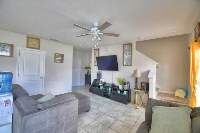 tiled living room featuring a textured ceiling and ceiling fan