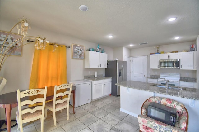 kitchen featuring white cabinetry, light stone countertops, light tile patterned floors, and stainless steel appliances