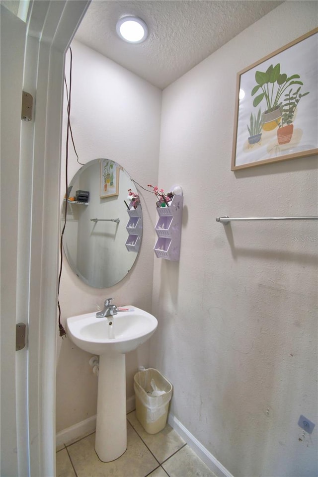 bathroom with a textured ceiling and tile patterned flooring