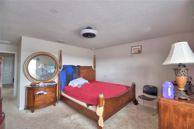 bedroom featuring a textured ceiling and light carpet