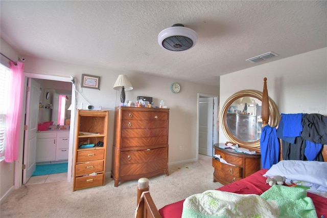 carpeted bedroom with a textured ceiling and ensuite bathroom