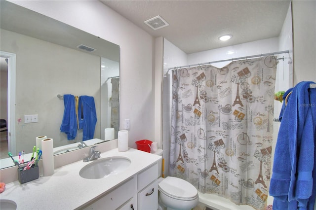 bathroom with toilet, vanity, a textured ceiling, and walk in shower