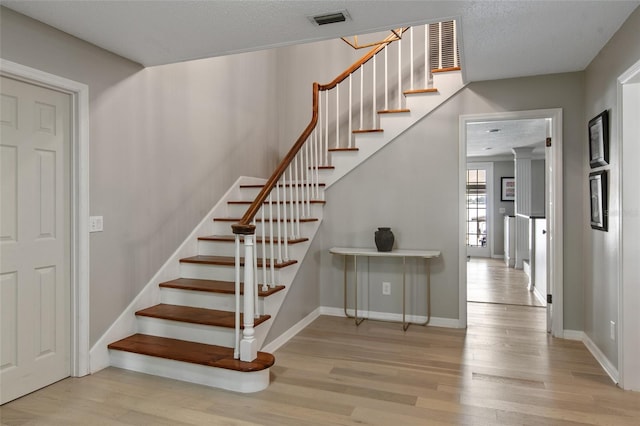 stairway featuring hardwood / wood-style flooring and a textured ceiling