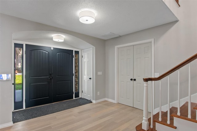 entrance foyer featuring light wood-type flooring and a textured ceiling