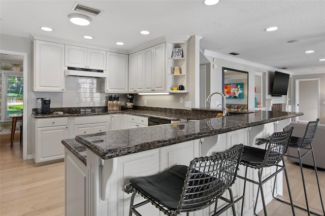 kitchen featuring kitchen peninsula and white cabinets