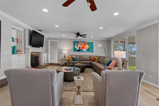 living room with light hardwood / wood-style flooring, ornamental molding, and a brick fireplace