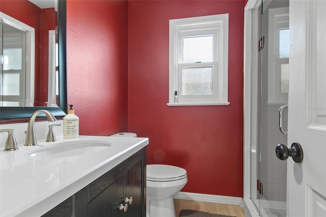 bathroom with vanity, toilet, and a shower with door