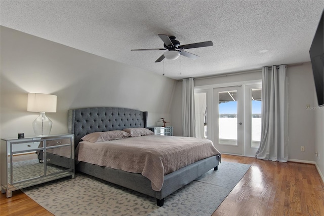 bedroom featuring hardwood / wood-style flooring, ceiling fan, a textured ceiling, and access to outside