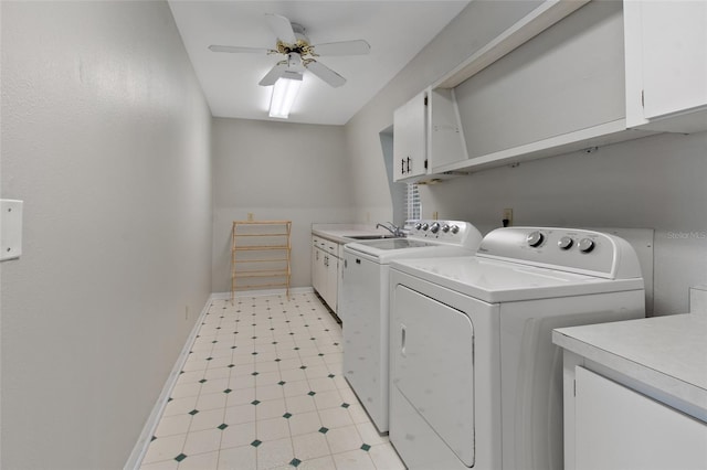 clothes washing area with ceiling fan, washer and clothes dryer, cabinets, and sink