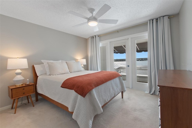 carpeted bedroom with ceiling fan, a textured ceiling, and access to outside