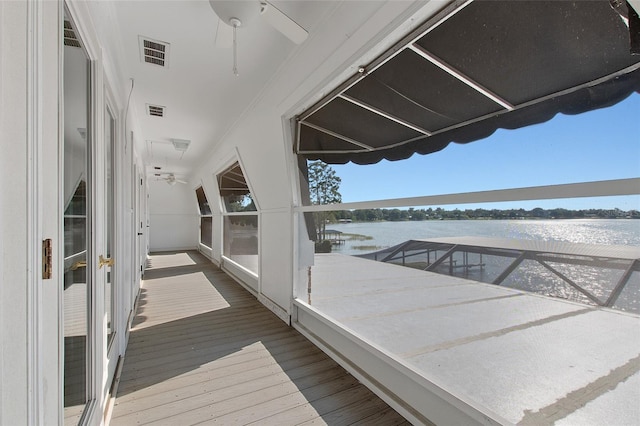 exterior space with ceiling fan and a water view