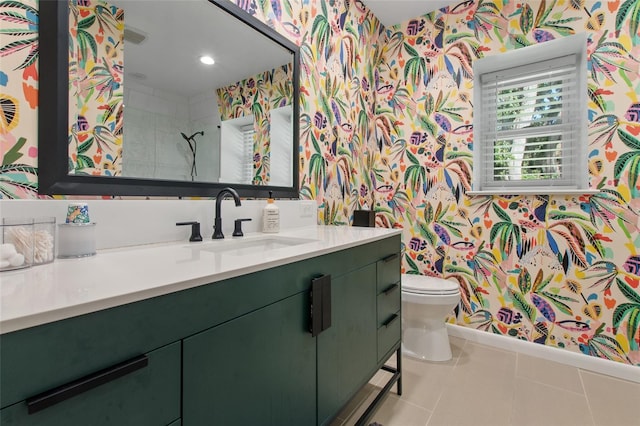 bathroom with tile patterned floors, vanity, a tile shower, and toilet