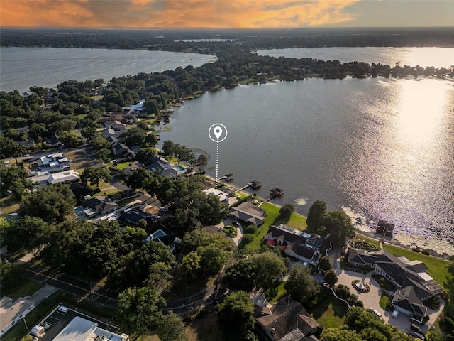 aerial view at dusk featuring a water view