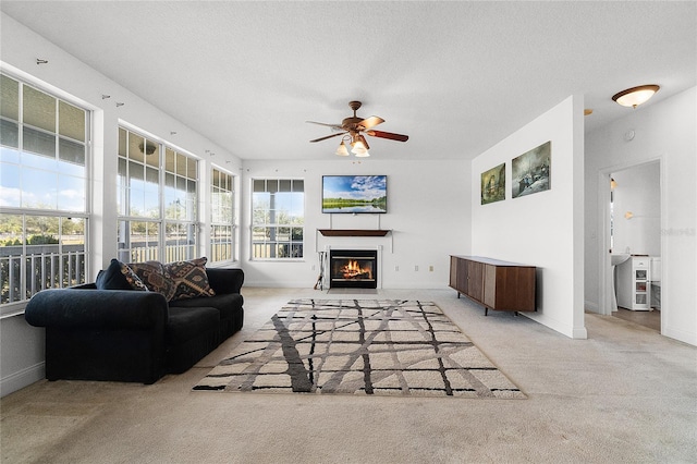 living room featuring ceiling fan, light colored carpet, and a textured ceiling