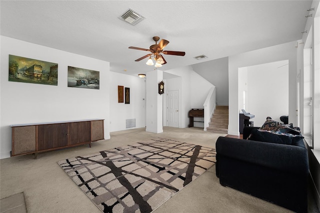 living room with light carpet, a textured ceiling, and ceiling fan