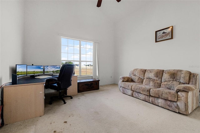 office space with carpet flooring, ceiling fan, and a towering ceiling