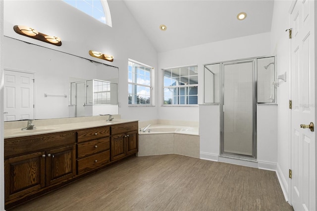 bathroom with hardwood / wood-style flooring, lofted ceiling, independent shower and bath, and vanity