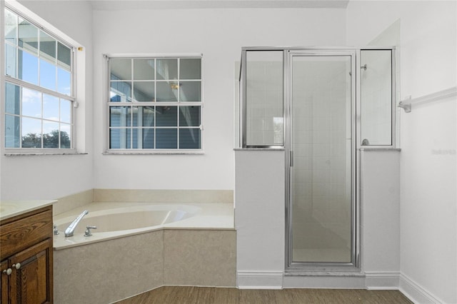 bathroom with vanity, hardwood / wood-style flooring, and shower with separate bathtub