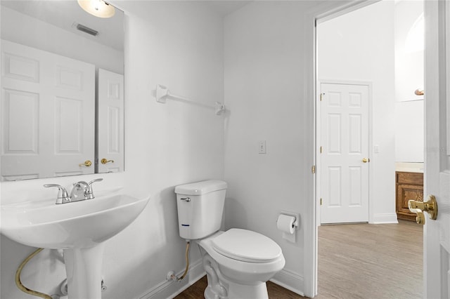 bathroom featuring wood-type flooring and toilet