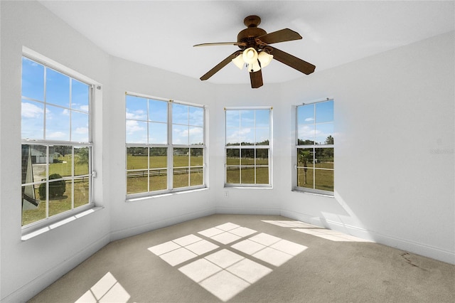 unfurnished sunroom with ceiling fan