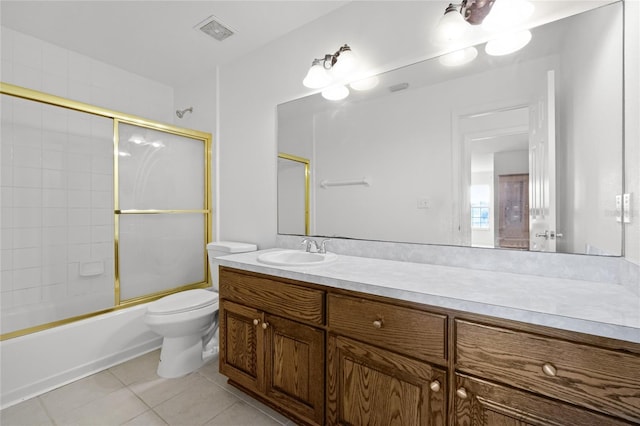 full bathroom featuring vanity, combined bath / shower with glass door, tile patterned floors, and toilet