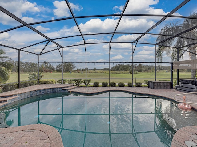 pool featuring glass enclosure, a patio, and a jacuzzi