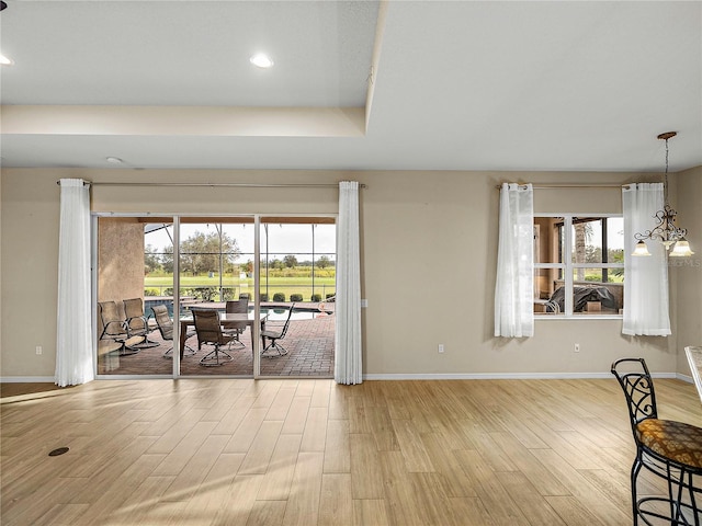 dining room featuring light wood-type flooring, a healthy amount of sunlight, and baseboards