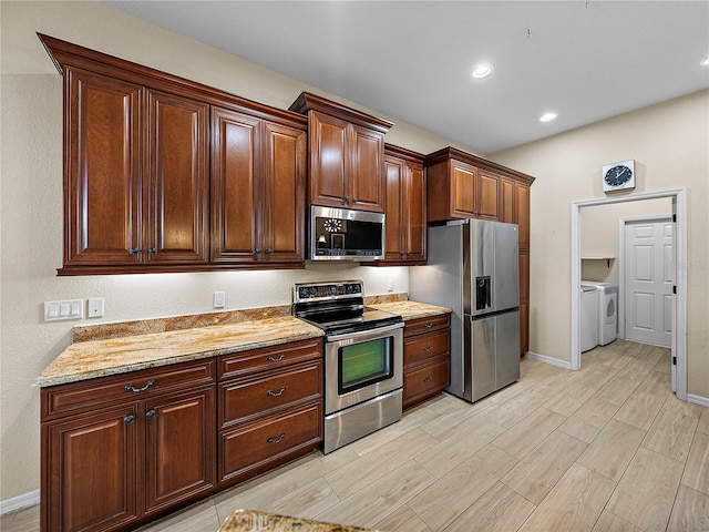 kitchen with washer and clothes dryer, light stone counters, stainless steel appliances, wood finish floors, and recessed lighting