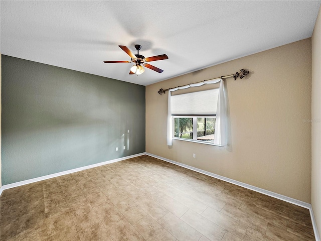 empty room featuring baseboards and a ceiling fan