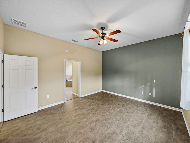 unfurnished bedroom with ensuite bath, baseboards, visible vents, and a ceiling fan