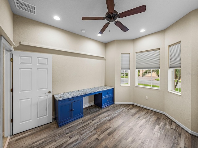 unfurnished office featuring recessed lighting, wood finished floors, visible vents, baseboards, and built in desk