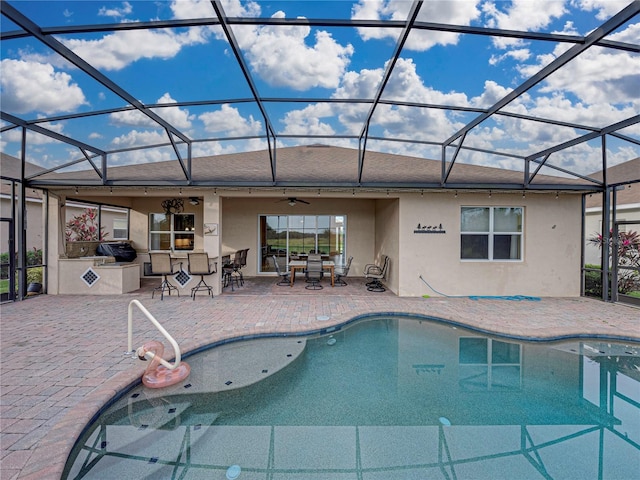 pool with ceiling fan, a patio, a lanai, area for grilling, and outdoor dry bar